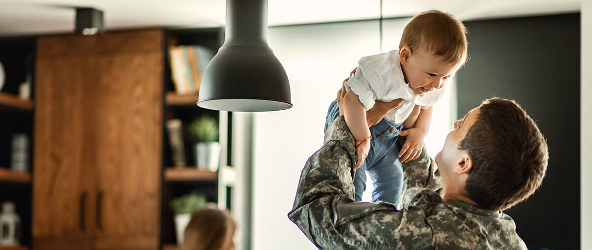 A veteran lifting his child in their newly renovated living room
