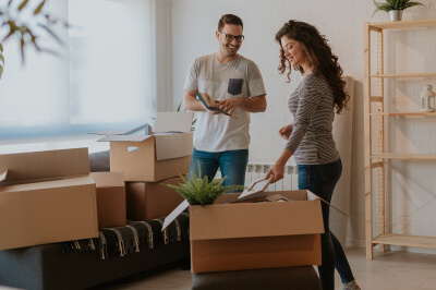 Couple unpacks boxes while moving into new home after closing on their house.