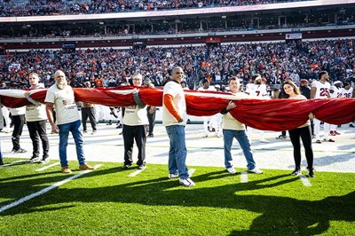 CrossCountry Mortgage Veteran and Military family members hold American flag during Cleveland Browns Salute To Service game